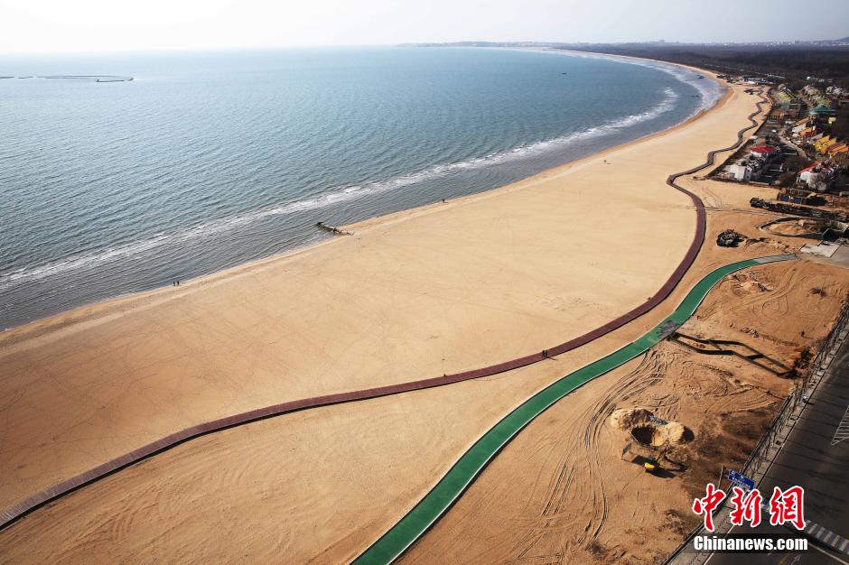 3月13日，秦皇島萬(wàn)米臨海沙灘木棧道。據(jù)了解，該木棧道全長(zhǎng)約4200米，與北戴河區(qū)原有的7500米木棧道對(duì)接后全線總長(zhǎng)度1.17萬(wàn)米，整個(gè)木棧道東起秦皇島體育基地游船碼頭，西至北戴河濕地公園，呈波浪形蜿蜒10.4公里海岸線。 中新社發(fā) 曹建雄 攝 CNSPHOTO